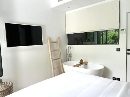 une salle de bain blanche avec un lavabo et une baignoire dans l'établissement Luxueux appartement Cinéma quartier du marais - 8P - FLAT-GUEST, à Paris