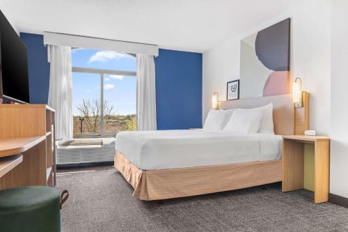 ein Schlafzimmer mit einem großen Bett und einem Fenster in der Unterkunft Spark By Hilton Charlotte Tyvola I-77 in Charlotte