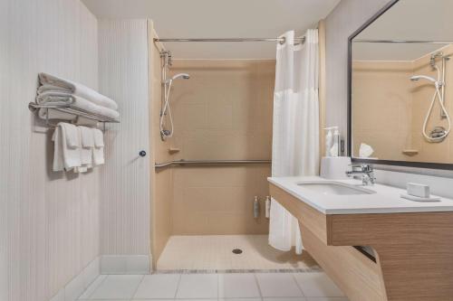 a bathroom with a shower and a sink and a mirror at Spark By Hilton Charlotte Tyvola I-77 in Charlotte