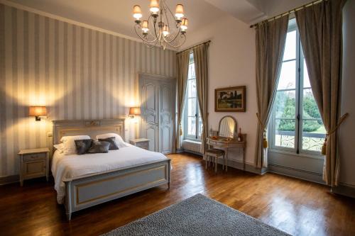 a bedroom with a bed and a chandelier at CHATEAU DE QUINCEY in Quincey