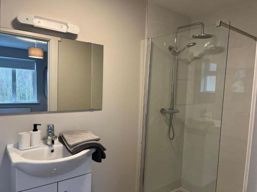 a bathroom with a glass shower and a sink at Bay Area House, Spiddal in Spiddal