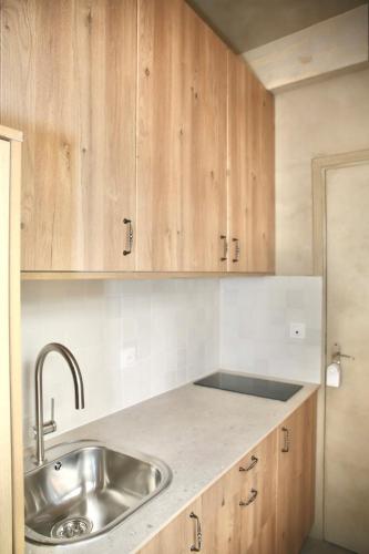 une cuisine avec un évier et des armoires en bois dans l'établissement Studio de charme pour un séjour en amoureux - 2P - FLAT-GUEST, à Paris