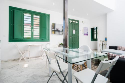 sala de estar con mesa de cristal y sillas blancas en Penthouse con terraza- 2D 2B- Triana, en Sevilla