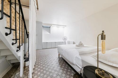 a white bedroom with a bed and a staircase at Séjour romantique avec bain à remous à Pigalle -P6 in Paris
