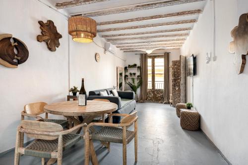 sala de estar con mesa, sillas y sofá en La Guarida Suites, en Barcelona