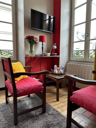 a living room with two chairs and a table at Camélia in Bayeux
