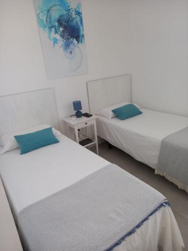 a room with two beds and a table with a night stand at Nunoli Duplex Luxury Playa Blanca in Playa Blanca