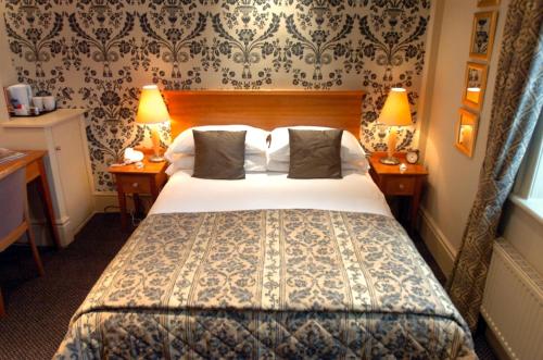 ein Hotelzimmer mit einem Bett und zwei Lampen in der Unterkunft Hotel Manor - Datchet, Windsor in Datchet