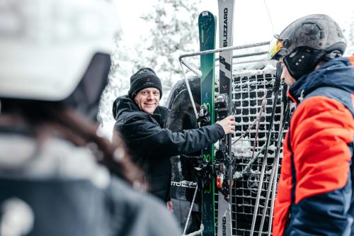 a man is holding skis in a rack at Hotel Hochschober in Turracher Hohe