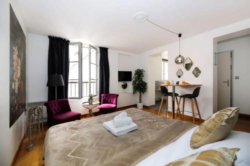 巴黎的住宿－502- Studio de charme dans quartier animé Paris 5，卧室配有一张床和一张桌子及椅子