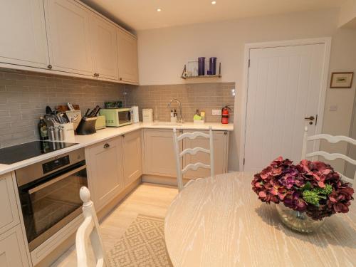 a kitchen with a table and a vase of flowers at Little Barn in Stockbridge