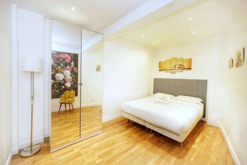 Schlafzimmer mit einem weißen Bett und einer Glasdusche in der Unterkunft Appartement moderne et élégant a Paris 5 - 4P in Paris