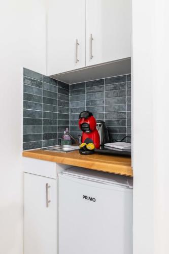 un appareil rouge posé dans un évier de cuisine dans l'établissement Studio proche sacre cœur - Paris 9 -2P - FLAT-GUEST, à Paris