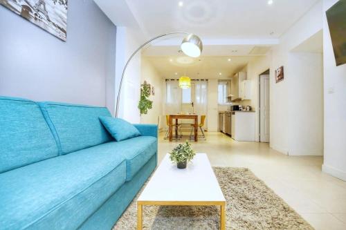 ein blaues Sofa im Wohnzimmer mit einem Tisch in der Unterkunft Appartement moderne et élégant a Paris 5 - 4P in Paris