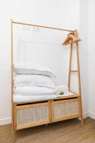 une pile d'oreillers blancs posés sur une étagère en bois dans l'établissement Jolie 2 pieces 35m2 bien équipée 4P - Paris 20 - FLAT-GUEST, à Paris