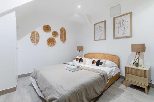 una camera bianca con letto e comodino di Espace moderne 40m2 a deux pas de Paris - 4P a Les Lilas