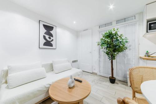 un soggiorno bianco con divano bianco e tavolo di Espace moderne 40m2 a deux pas de Paris - 4P a Les Lilas