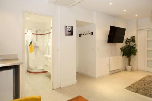 a white room with a shower and a tv on a wall at RDJ - Appartement tout confort au cœur de Paris 5 in Paris
