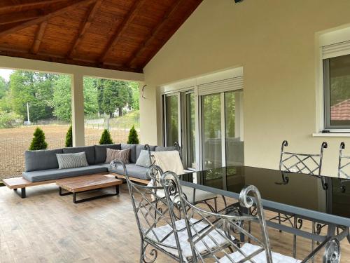 a patio with a couch and a table and chairs at Vip kuca Banja Vrujci in Popadić