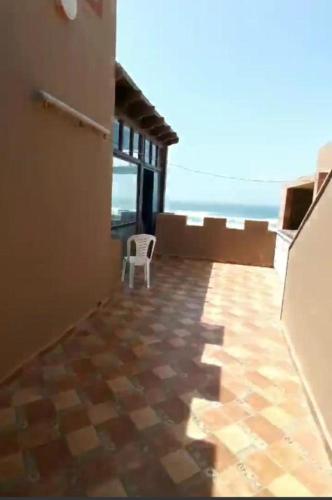 a room with a chair and a view of the ocean at palmerais daglou in Tiznit