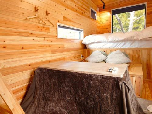 una baita di tronchi con un letto in camera di CampBaseKadojin - Vacation STAY 73760v a Tenkawa