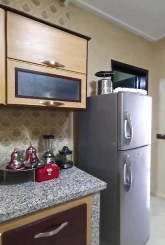 a kitchen with a refrigerator and a counter top at palmerais daglou in Tiznit