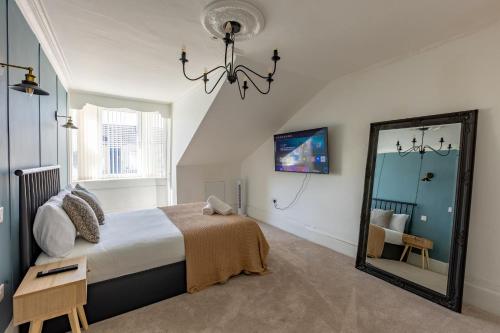 a bedroom with a large bed and a mirror at Spacious 3 Bedroom Home In Glasgow - Free Parking in Glasgow