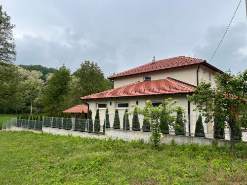a house with a fence next to a field at Vip kuca Banja Vrujci in Popadić