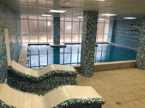 uma grande piscina com bancos e uma piscina em Хотел "Загоре" em Starozagorski Bani