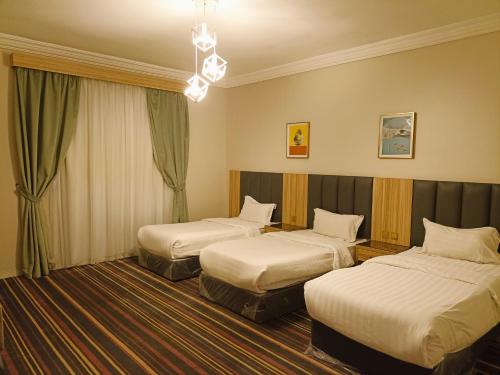 Alhamra Park hotel في جدة: غرفة فندقية بسريرين وثريا