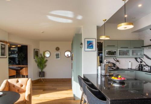 a kitchen and living room with a table and chairs at Sruthan Pier House in Carraroe