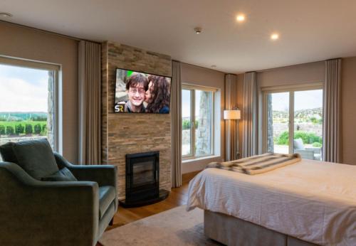 a bedroom with a bed and a fireplace and a tv at Sruthan Pier House in Carraroe