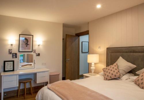 a bedroom with a bed with a desk and a bed sidx sidx sidx at Sruthan Pier House in Carraroe