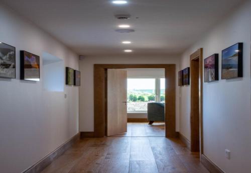 a room with a hallway with a door and a window at Sruthan Pier House in Carraroe