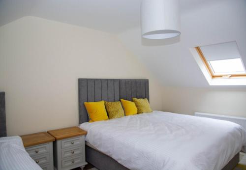 a bedroom with a bed with yellow pillows at Sruthan Pier House in Carraroe