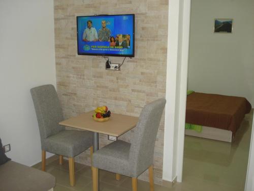 a room with a table and chairs and a tv on a wall at Apartments Villa Danilovic in Herceg-Novi
