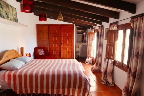 a bedroom with a bed with a red and white striped blanket at Casa Paradís in Callosa d'en Sarrià
