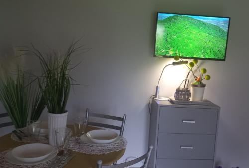 a dining room table with a television on a wall at Domek Karłowo u Eli in Sierakowice
