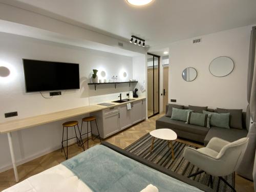 a living room with a couch and a tv at Salt Garden Apartments in Druskininkai