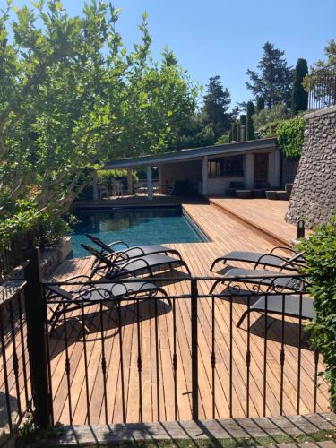 un groupe de chaises assises à côté d'une piscine dans l'établissement L'Estaou de Finou - Meublé de Tourisme 3 Étoiles, à Saint-Paul-et-Valmalle