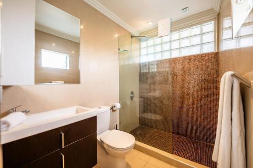 e bagno con servizi igienici, lavandino e doccia. di Riverside Studio apartment with parking a Brisbane