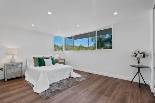 - une chambre blanche avec un lit et une fenêtre dans l'établissement Dumetz by AvantStay Large Private Outdoor Area, à Los Angeles