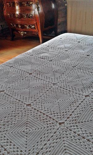 a bed with a white comforter on top of it at Casa Rural A Pasada in Cedeira
