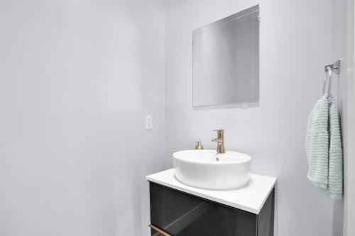uma casa de banho branca com um lavatório e um espelho em Hinds by AvantStay Duplex in North Hollywood em Los Angeles