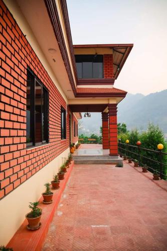 a brick building with a walkway with potted plants at Doleshwor Village Resort & Farm House in Bhaktapur