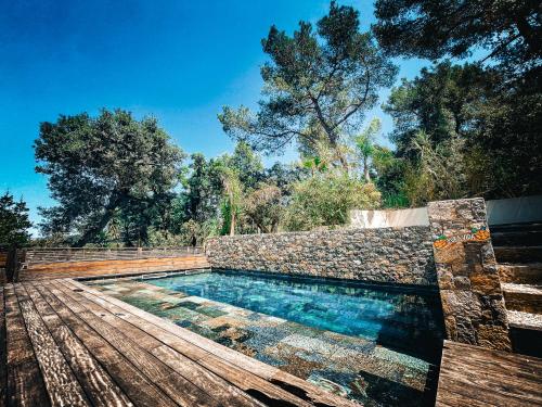 une piscine avec un banc sur une terrasse en bois dans l'établissement Villa Costa Ricaine, à Six-Fours-les-Plages