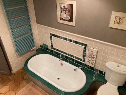 une salle de bain avec baignoire et toilettes dans l'établissement Le Patio, à Laouque