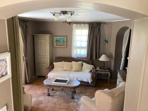 un salon avec un lit et une table dans l'établissement Le Patio, à Laouque