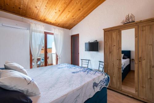 ein Schlafzimmer mit einem Bett und einem TV an der Wand in der Unterkunft Casa Meazza-Apartman Nero in Medulin