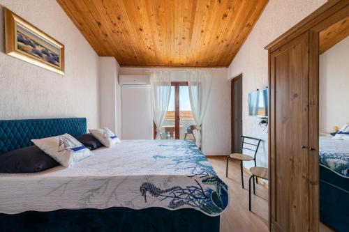 ein Schlafzimmer mit einem Bett und einer Holzdecke in der Unterkunft Casa Meazza-Apartman Nero in Medulin